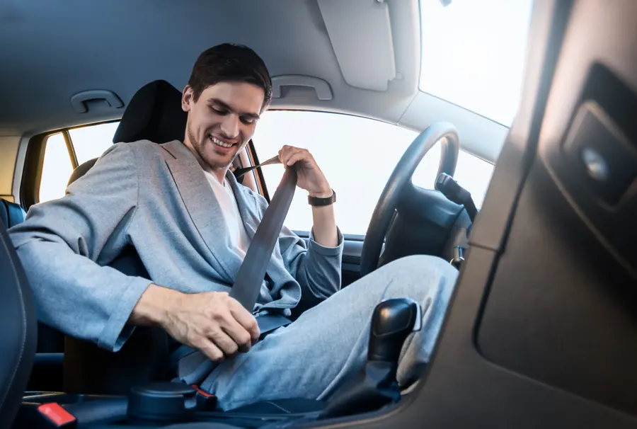Occupant drawing the seat belt across the body before fastening it