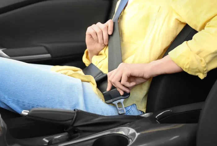 Occupant fastening a seat belt buckle at the side of the seat cushion