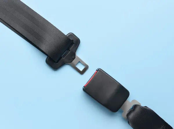 Seat belt assembly halves laid flat on a light surface